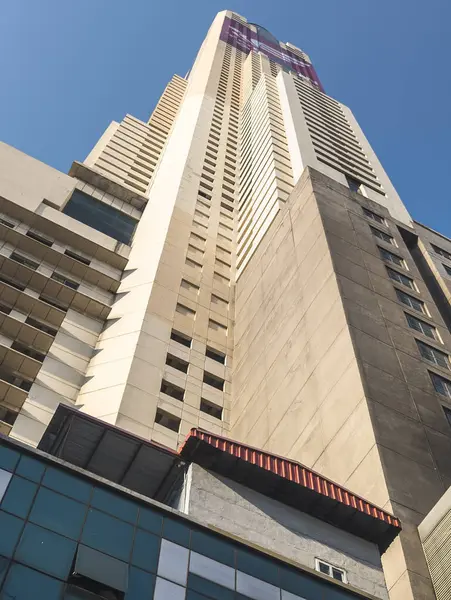 Bangkok, Tayland-07 Nisan 2024 Aşağıdaki sokaklardan yukarıya, 88 katlı bina güneş ışığına doğru yükseliyor ve yukarıdaki açık mavi gökyüzü büyük bir şehir simgesi haline geliyor..