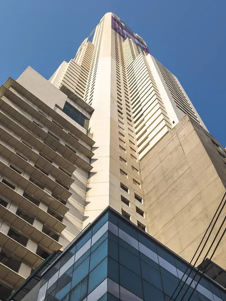 Bangkok, Tayland-07 Nisan 2024 Aşağıdaki sokaklardan yukarıya, 88 katlı bina güneş ışığına doğru yükseliyor ve yukarıdaki açık mavi gökyüzü büyük bir şehir simgesi haline geliyor..