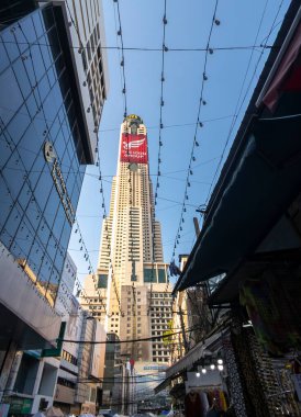 Tayland-Nisan 07-2024 Birçok insan, Baiyoke Gökyüzü Oteli 'nin güneş ışığının ötesine yükselmesiyle öğleden sonra açık bir pazarda mal satın alıyor..