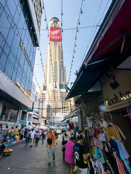 Tayland-Nisan 07-2024 Birçok insan, Baiyoke Gökyüzü Oteli 'nin güneş ışığının ötesine yükselmesiyle öğleden sonra açık bir pazarda mal satın alıyor..