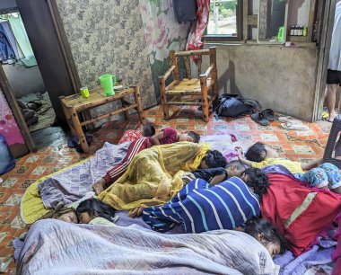 Mindanao, Filipinler - 13 Nisan 2024: Sabahın erken saatlerinde, birçok çocuk ve anne yoksul bir çevrede, birlikte uyurlarken güvende hissederek, küçük bir konutun zemininde yatıyorlar..