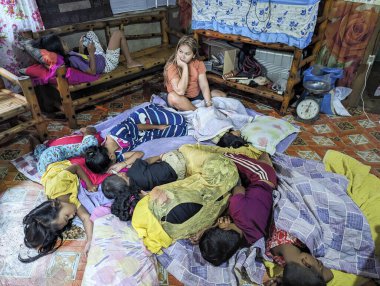 Mindanao, Filipinler - 13 Nisan 2024: Zavallı bekar bir anne, sabahın erken saatlerinde, çocuklarıyla birlikte, hala tek odalı bir konutun zemininde uyuyor.