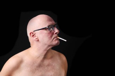 Sabah kalktıktan sonra sigara yakmak üzere olan yetişkin bir erkeğin stüdyo portresi..