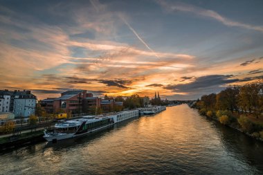 Regensburg, Bavyera, Almanya, 16 Ekim 2022: Tuna ve katedral ve taş köprüyle gün batımı