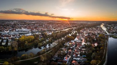 Bavyera 'daki Regensburg şehrinin Panorama' sı Tuna nehri katedrali ve sonbaharda Almanya 'da günbatımında taş köprü.