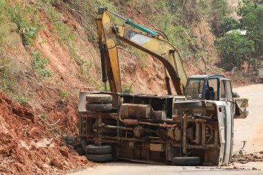 İnşaat alanında kaza yapan bir çöp kamyonu kazıcılarla yollara itiliyor. İnşaat alanında kendimi güvende hissetmiyorum.