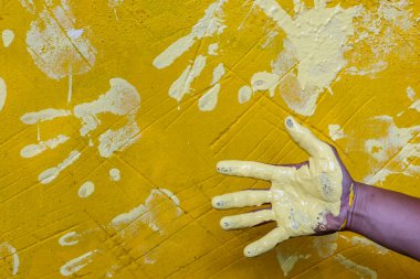 Seçici odak: Beyaz lekeli ev hanımının sarı bir duvarda el izi oluşması onu bir avuç içi şekline getirir. Duvarları süslemek, kendi başına sanat yaratmak için..