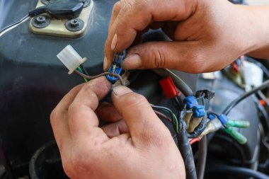 Araba tamircisinin elindeki kabloları ayırmak için seçici odaklı elektrikli köprü. Arabanın elektrik sistemi tamir ediliyor..