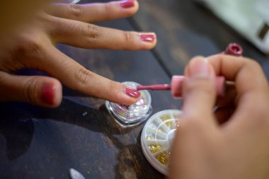 Asyalı kadınların tırnaklarını seç. Evde tırnaklarımı süslüyorum..