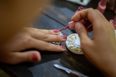 Asyalı kadınların tırnaklarını seç. Evde tırnaklarımı süslüyorum..