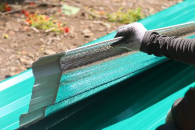 Bina malzemeleri satan bir dükkandan alınan galvanizli yeni bir çarşafa iliştirilmiş seçici odaklı ısı kalkanı. Bir araba tamirhanesinin çatısına kurulum için..