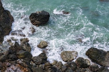 Deniz kenarındaki kayaların yüksek açılı manzarası adadaki dağdan serin esinti, yeşil ağaçlar ve mavi deniz manzarası. Tayland 'da yaz aylarında hava güzel ve ferahlatıcıdır..