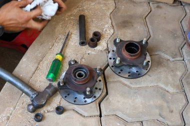 Seçici odak motorsiklet disk fren diski kaldırıldı ve tekerlek bilyelerini yenileriyle değiştirerek onarılmaya ayarlandı.