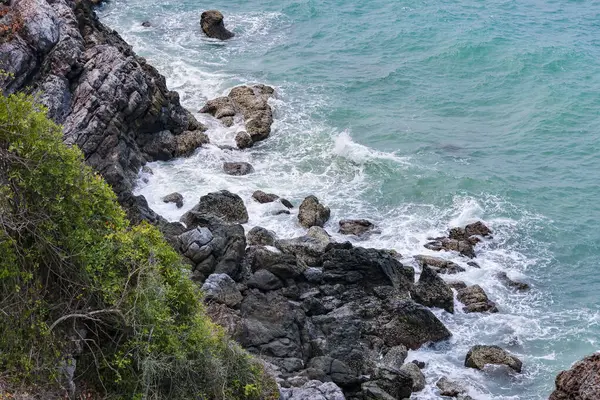 Deniz kenarındaki kayaların yüksek açılı manzarası adadaki dağdan serin esinti, yeşil ağaçlar ve mavi deniz manzarası. Tayland 'da yaz aylarında hava güzel ve ferahlatıcıdır..