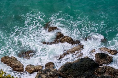 Deniz kenarındaki kayaların yüksek açılı manzarası adadaki dağdan serin esinti, yeşil ağaçlar ve mavi deniz manzarası. Tayland 'da yaz aylarında hava güzel ve ferahlatıcıdır..