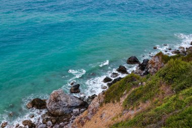 Deniz kenarındaki kayaların yüksek açılı manzarası adadaki dağdan serin esinti, yeşil ağaçlar ve mavi deniz manzarası. Tayland 'da yaz aylarında hava güzel ve ferahlatıcıdır..
