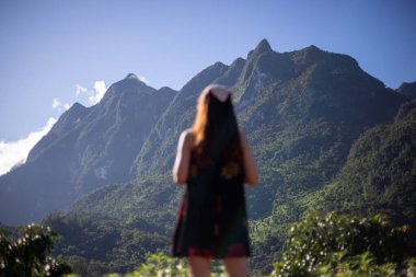 Doi Luang Chiang Dao güzel şekilli büyük yeşil dağlara odaklanmak hayvanlar için bir koruma alanıdır. Bulanık ön plan, genç Asyalı bir kadının... 
