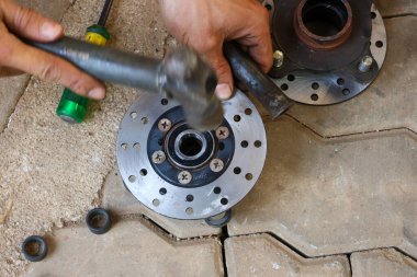 Seçici odak motorsiklet disk fren diski kaldırıldı ve tekerlek bilyelerini yenileriyle değiştirerek onarılmaya ayarlandı.