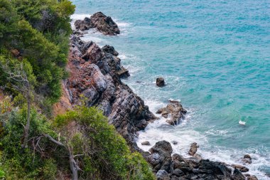 Deniz kenarındaki kayaların yüksek açılı manzarası adadaki dağdan serin esinti, yeşil ağaçlar ve mavi deniz manzarası. Tayland 'da yaz aylarında hava güzel ve ferahlatıcıdır..