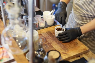 Taze ve temiz kahve içen bir dükkandaki baristanın elindeki seramik bardakta seçici siyah kahve.