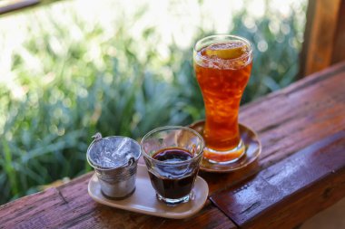 Seçici odaklı soğuk içecek Craft Cola buzla dolu güzel, berrak bir bardak ve üstüne bir dilim limon. Bir bardak sade kahve ve bir bardak buzla servis et.