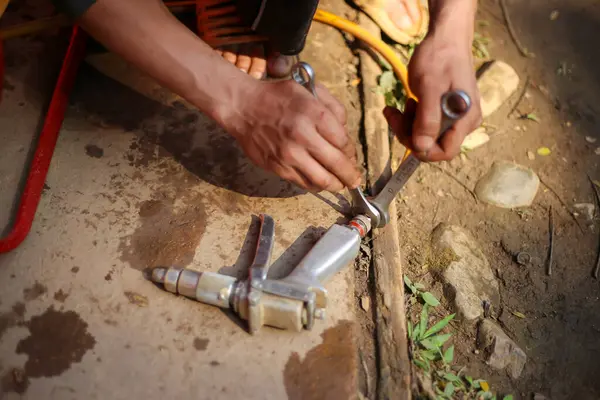 Seçici odaklı yüksek basınçlı su hortumu, araba yıkama için yüksek basınçlı su püskürtme hortumunun elindeki ingiliz anahtarıyla sıkılıyor.