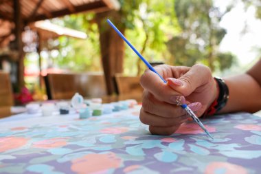 Orta yaşlı Asyalı bir kadının elindeki Phukan suluboya hayal gücünü güçlendirmek için boş zamanlarında resim yapıyor. Hayattaki stresi azaltmak için resimler çiz. Bırak sanat kalbi iyileştirsin..