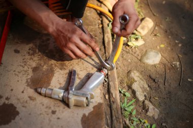 Seçici odaklı yüksek basınçlı su hortumu, araba yıkama için yüksek basınçlı su püskürtme hortumunun elindeki ingiliz anahtarıyla sıkılıyor.