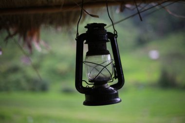 Pirinç tarlasının ortasında bir kulübenin önündeki antika, antika bir fenerin yakın çekimi..