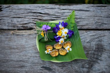Seçici odaklanma Ricefield yengeçleri kabuklarında. Na 'nın yemesini ve tabağı doğal çiçeklerle süslemesini izle. Muz yapraklarına sarılı pilavla ye. Basit Tayland yemekleri pirinç tarlalarında bulunur..