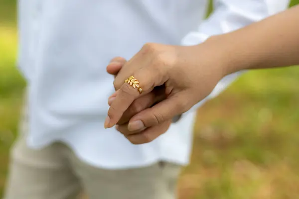 selective focus gold diamond ring on the young woman\'s hand He is holding a young woman\'s hand after putting on a ring and proposing to her.