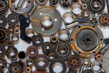 Paslı arka planı olan eski araba ve eski motosiklet parçaları paslı metal araba parçaları ve beyaz arka planda bir tamircinin artıklarıyla aynı hizaya geldi..