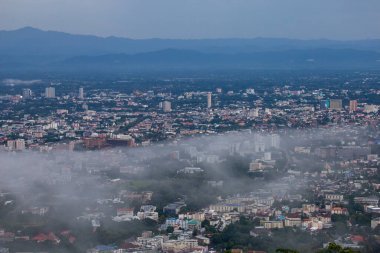 Şehrin yüksek açılı manzarası ve içinden sis geçiyor. Chiang Mai, Tayland 'da birçok bina var.