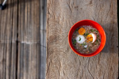 Tayland usulü haşlanmış yumurtalı kıymalı domuz püresi. Turuncu bardakta kahvaltı enerjiyi arttırır.