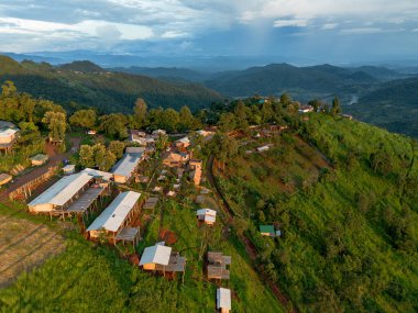 Yüksek açılı bir manzara, etrafı ormanlarla çevrili bir dağ köyü, Tayland 'da doğanın ortasında, ve açık bir gökyüzü. İHA 'nın kuş bakışı görüntüsü