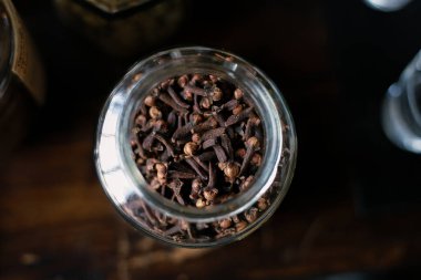 Temiz cam bir kavanozda kurumuş karanfil tomurcuğu. Kokulu bitkiler, baharatlar, tıbbi özellikler.