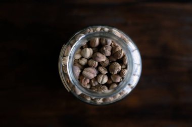 Seçici odak, iyi kalite cam kavanozda kurutulmuş kakule bitkisel çay dükkanında çiçekler.