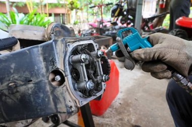 ATV motor başı uzman bir tamirci tarafından tamir edilmek üzere sökülüyor. Motor tamir ediliyor..
