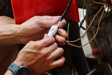 Elindeki elektrik prizini kapat, bir motorun elektrik sistemini onar..