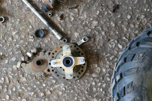 ATV 'nin fren diski tamir için söküldü. Otomobil tamirhanesinde yedek parça.