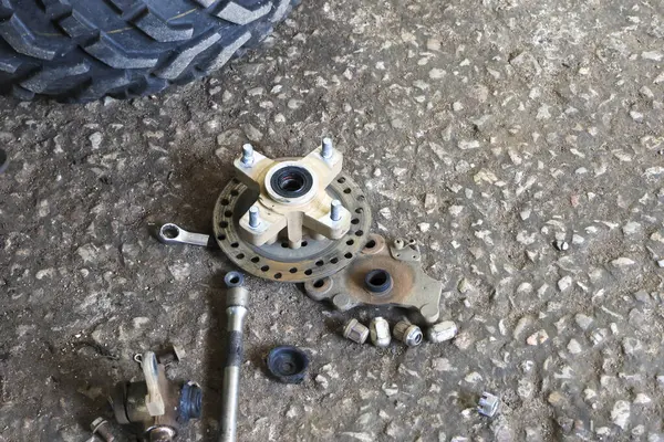 ATV 'nin fren diski tamir için söküldü. Otomobil tamirhanesinde yedek parça.