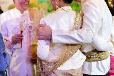 Seçici odaklanma. Bir erkeğin elleri kutlama partisinde bir kadının omuzlarına sevgiyle sarılır.