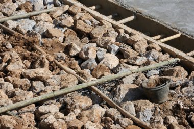 Kaya bariyeri, yolun çökmesini önlemek için bir kaya bariyeri oluşturmak için ağın etrafına sarılmış çelik tellerden yapılmıştır. Yol inşaatçıları ağlara taş koymak için tel örüyorlar..