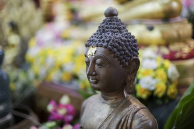 Huzurlu Buda heykeli sakin, düşünceli bir ifade sergiliyor, huzur saçıyor. Karanlık, antik heykel altın süslemeleri, kutsal içinde ruhani aydınlanmayı ve bağlılığı sembolize eder.