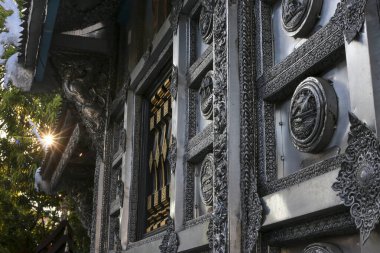 Karmaşık oymalar içeren görkemli bir cephe geleneksel bina, antik mimari detaylar sergileniyor. Altın güneş ışınları, ışık saçan dekoratif tasarımlar ve duyuları uyandırır.