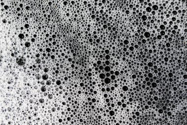 Beyaz köpük ve sayısız kabarcıklar ilgi çekici ve soyut bir doku oluşturur. Yüzeyde sabunlu yıkama bu temiz ortamın makro görüntüsünü sağlar, saf ve huzurlu hissi uyandırır.