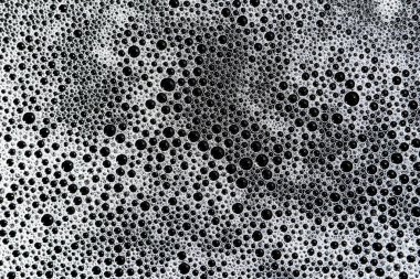 Büyüleyici soyut makro fotoğrafçılık köpük kabarcıkları sergiliyor, dinamik sıvı yüzey boyunca hassas doku ve desen oluşturuyor. Köpüklü sabun ve köpük, sayısız köpük oluşturur.