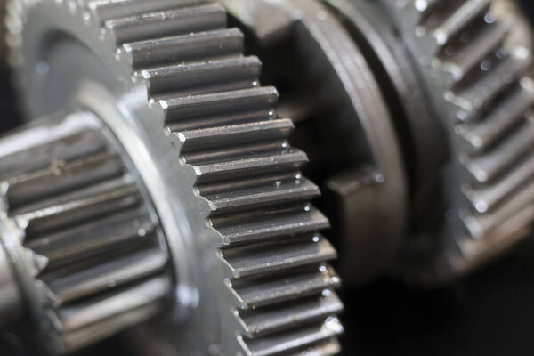 Крупный план металлических шестерен, показывающих механическую мощность и техническую точность, вызывающих чувство промышленной прочности и сложной конструкции