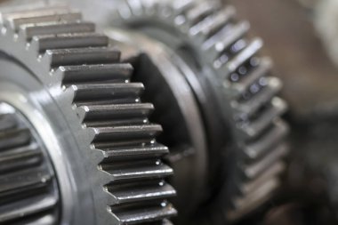 Metalik dişlileri kapatın, birbirine kenetlenmiş dişlerini vurgulayın ve karmaşık tasarım, mekanik hassasiyet ve endüstriyel güç hissi uyandırın.