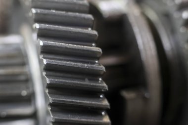 Çürük metal dişlerini ve yıpranmış yüzeyini gösteren, endüstriyel makineler ve mekanik işlevleri çağrıştıran, yıpranmış metal teçhizat.